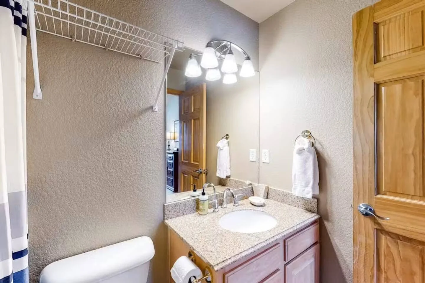 North Pond Retreat, Bathroom with a wood vanity, mirror, toilet, and shower curtain, waterfront vacation rental in Silverthorne, Colorado