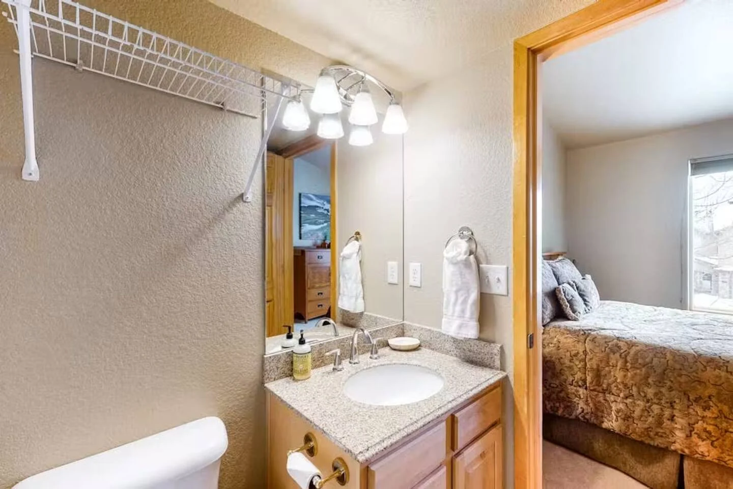 North Pond Retreat, Bathroom vanity and shower curtain beside a doorway with wood trim, waterfront vacation rental in Silverthorne, Colorado