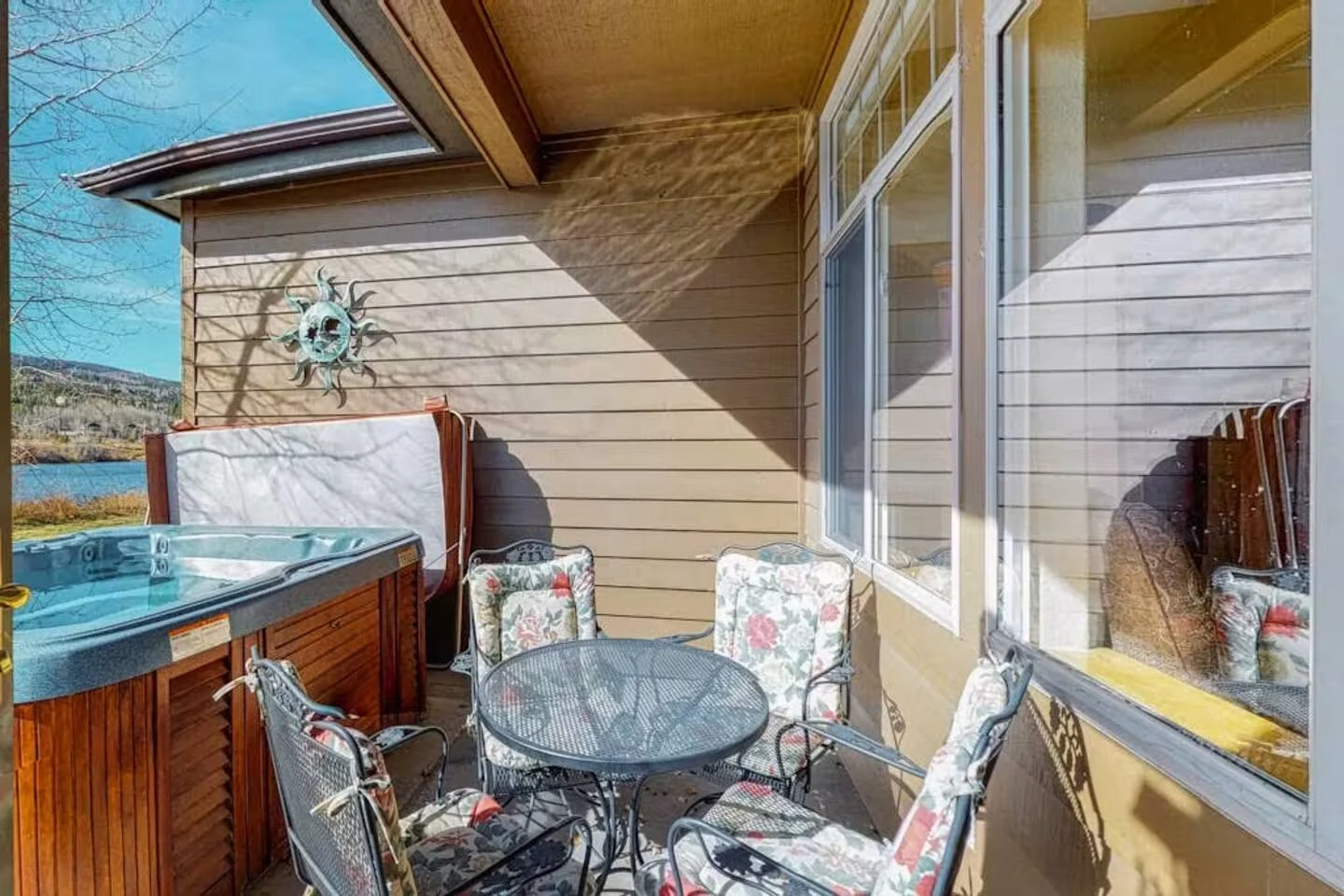 North Pond Retreat, Patio table and chairs beside the hot tub and glass doors of the home, waterfront vacation rental in Silverthorne, Colorado