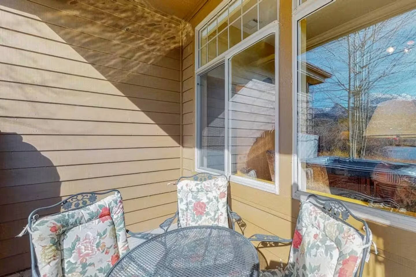 North Pond Retreat, Round outdoor table and cushioned chairs beside the patio's glass doors, waterfront vacation rental in Silverthorne, Colorado