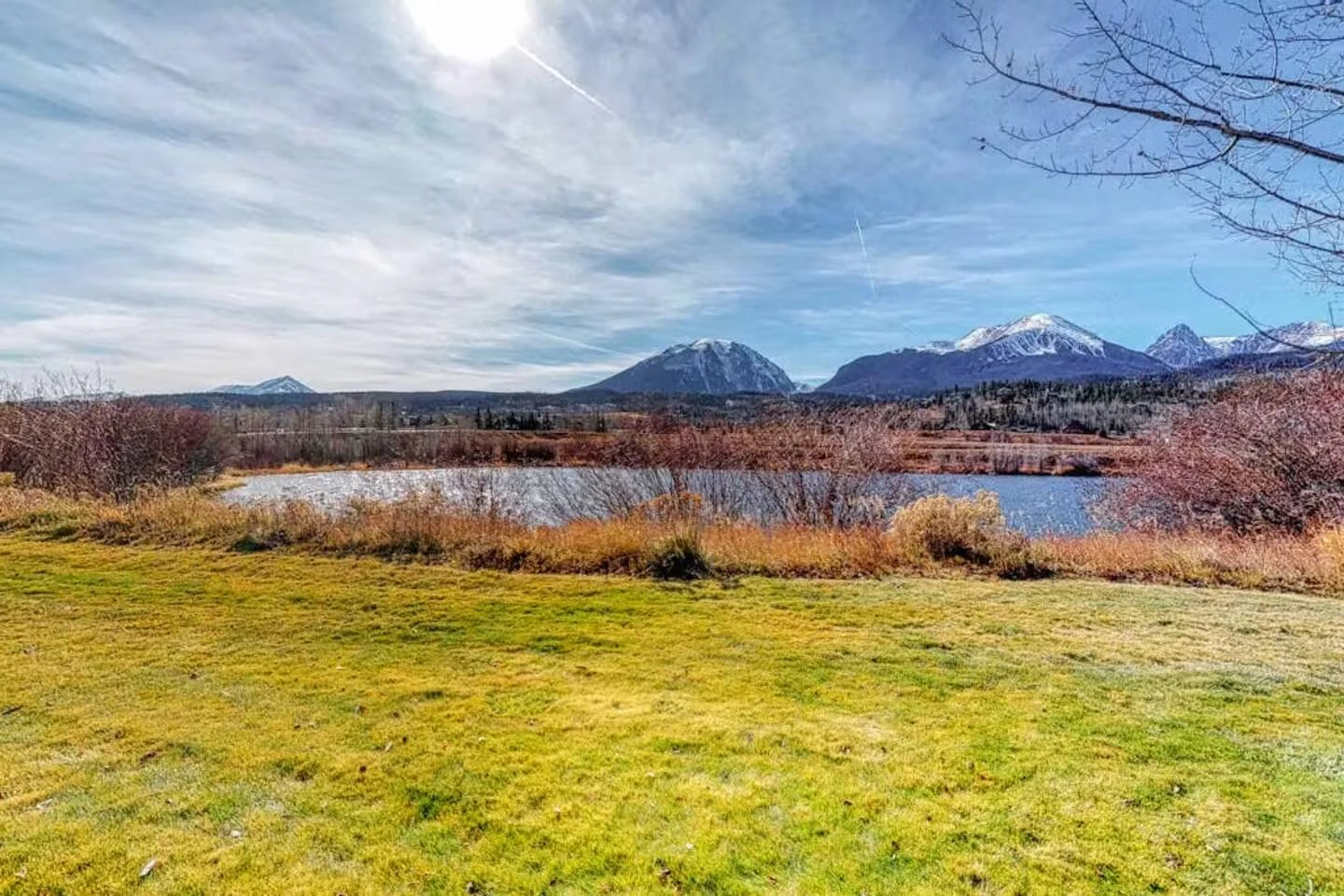 North Pond Retreat, Grassy waterfront yard with the pond and mountain range beyond, waterfront vacation rental in Silverthorne, Colorado