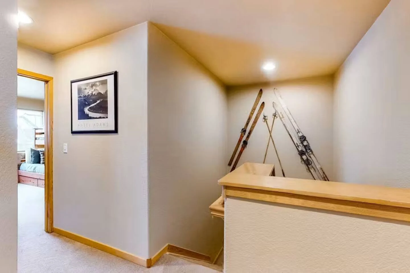 North Pond Retreat, Interior stairway landing with decorative skis, framed artwork, and a wood handrail, waterfront vacation rental in Silverthorne, Colorado