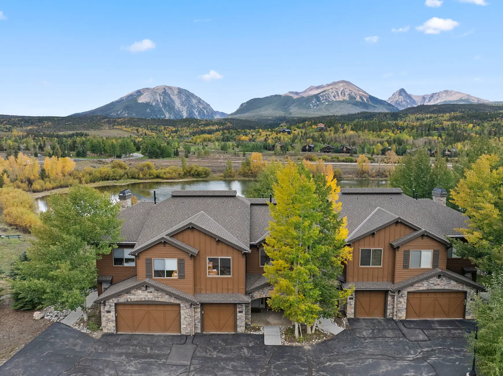 North Pond Retreat, Elevated view of the homes and garages with trees and mountain peaks beyond, waterfront vacation rental in Silverthorne, Colorado