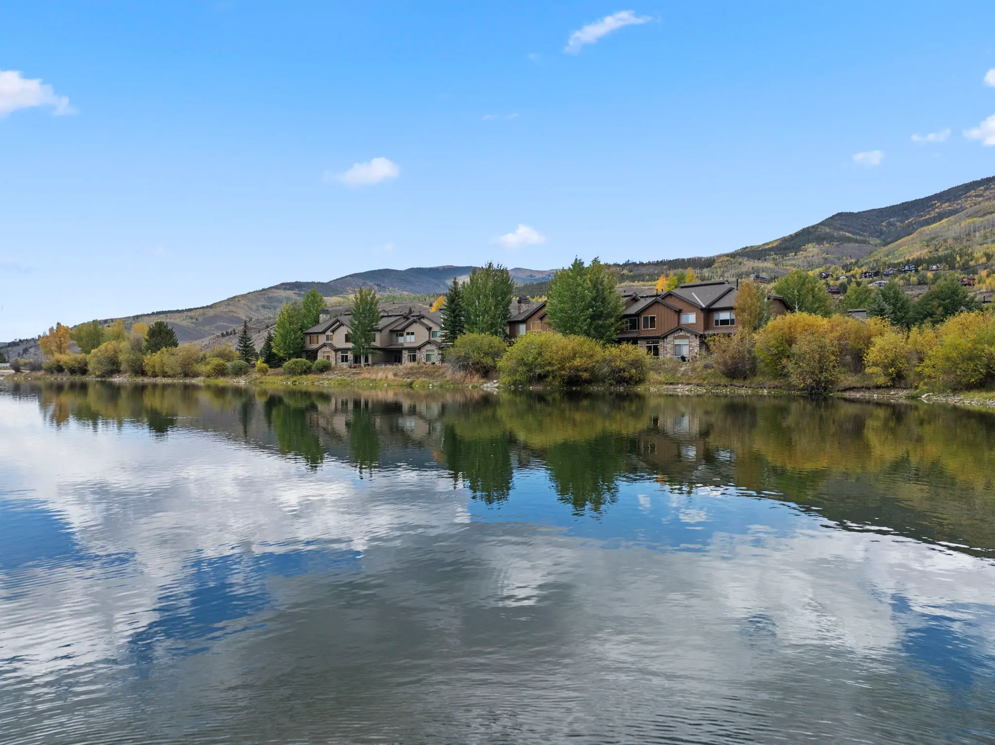North Pond Retreat, Calm pond reflecting trees, homes, and the blue sky, waterfront vacation rental in Silverthorne, Colorado