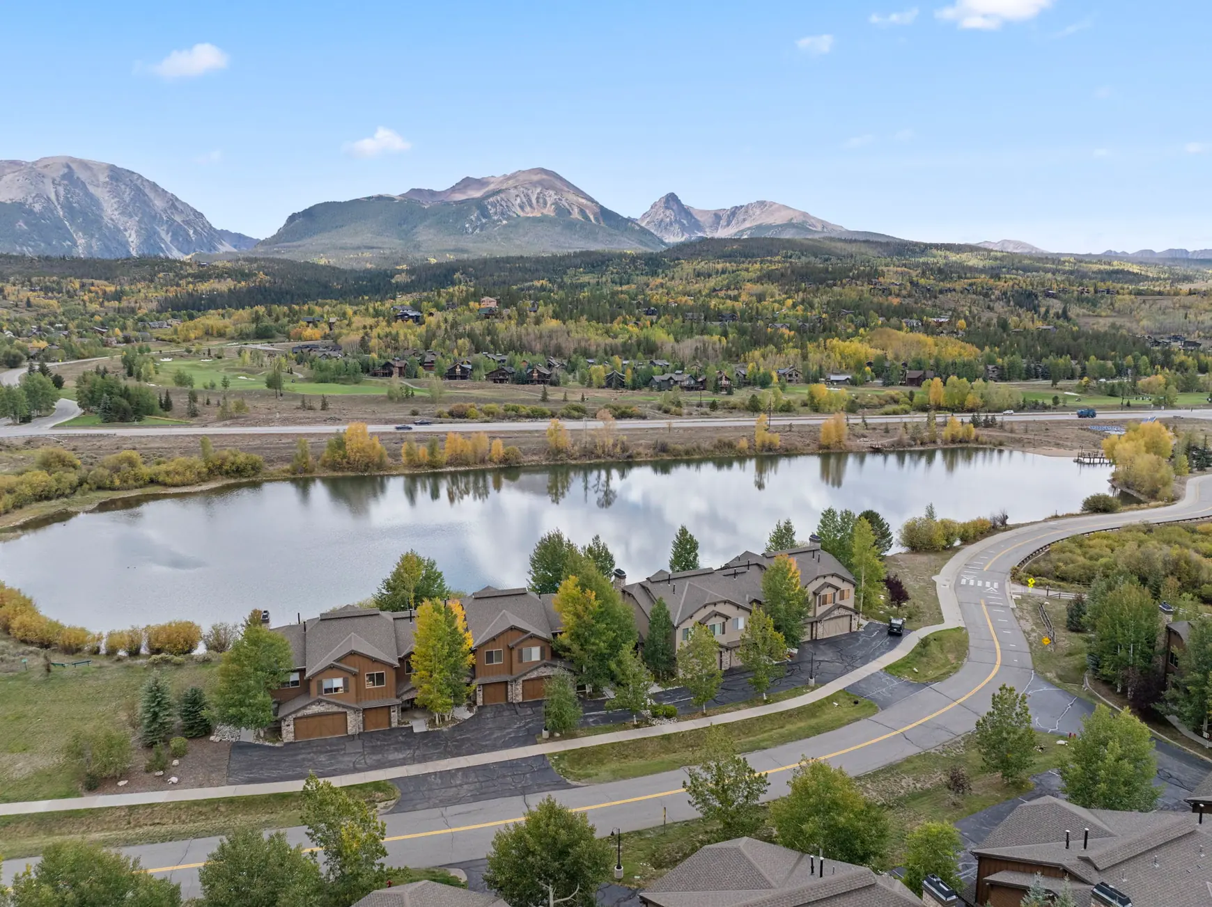North Pond Retreat, Aerial view of the pond, waterfront homes, a curving road, and mountain peaks, waterfront vacation rental in Silverthorne, Colorado