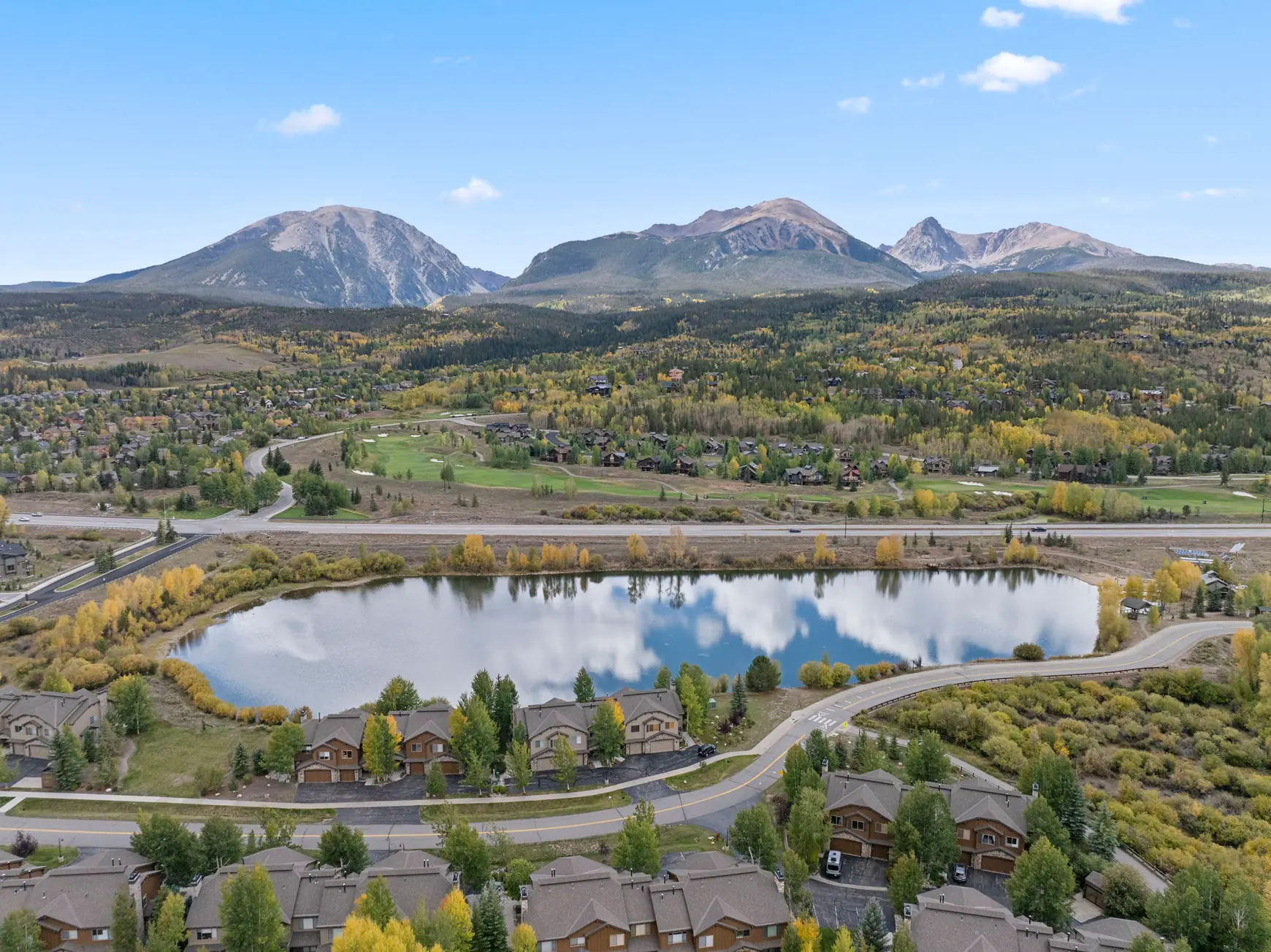 North Pond Retreat, Wide aerial view of the pond and surrounding valley with autumn trees and mountain peaks, waterfront vacation rental in Silverthorne, Colorado