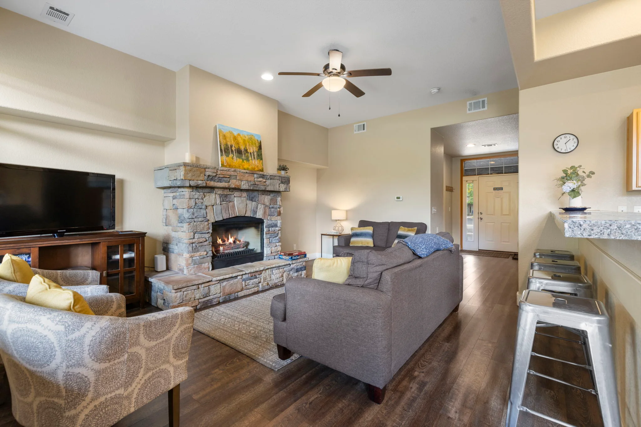 North Pond Retreat, Open living area with a stone fireplace, television, sofas, and kitchen counter, waterfront vacation rental in Silverthorne, Colorado