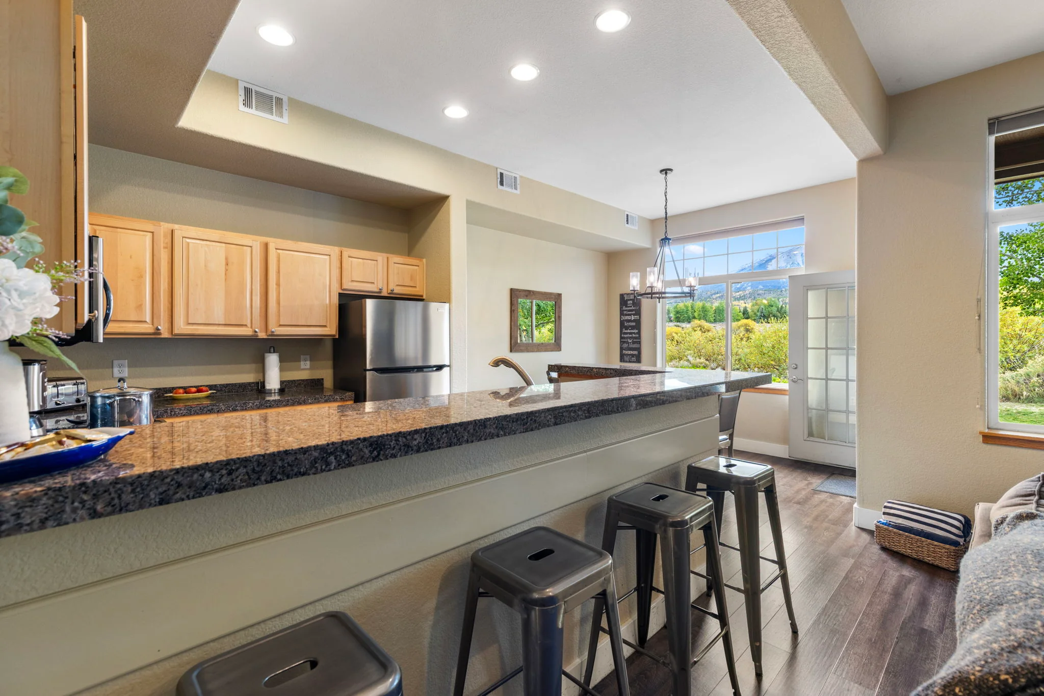 North Pond Retreat, Breakfast counter and bar stools beside the kitchen's light wood cabinetry, waterfront vacation rental in Silverthorne, Colorado