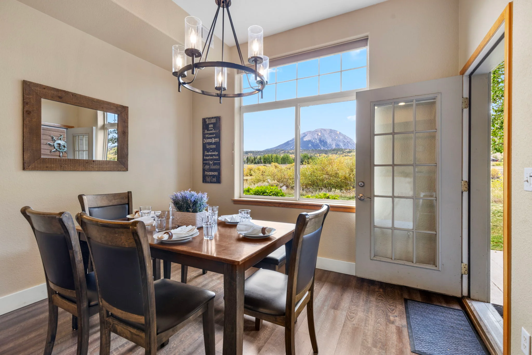 North Pond Retreat, Dining table with place settings beneath a chandelier beside a window with mountain views, waterfront vacation rental in Silverthorne, Colorado