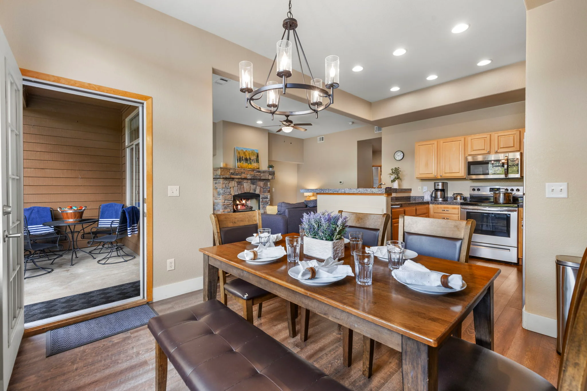 North Pond Retreat, Wood dining table with place settings and upholstered seating beside the open kitchen, waterfront vacation rental in Silverthorne, Colorado