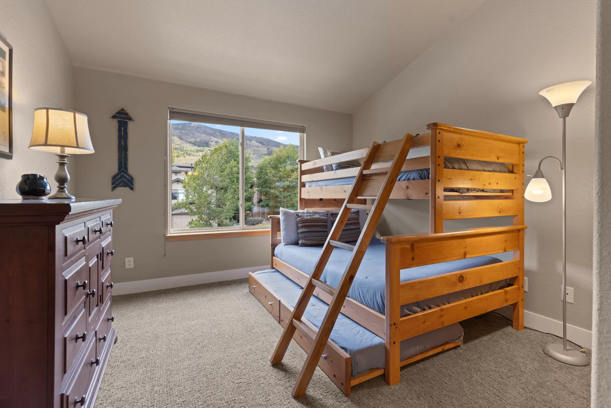 North Pond Retreat, Wood bunk bed with blue bedding beside a dresser and a large window, waterfront vacation rental in Silverthorne, Colorado