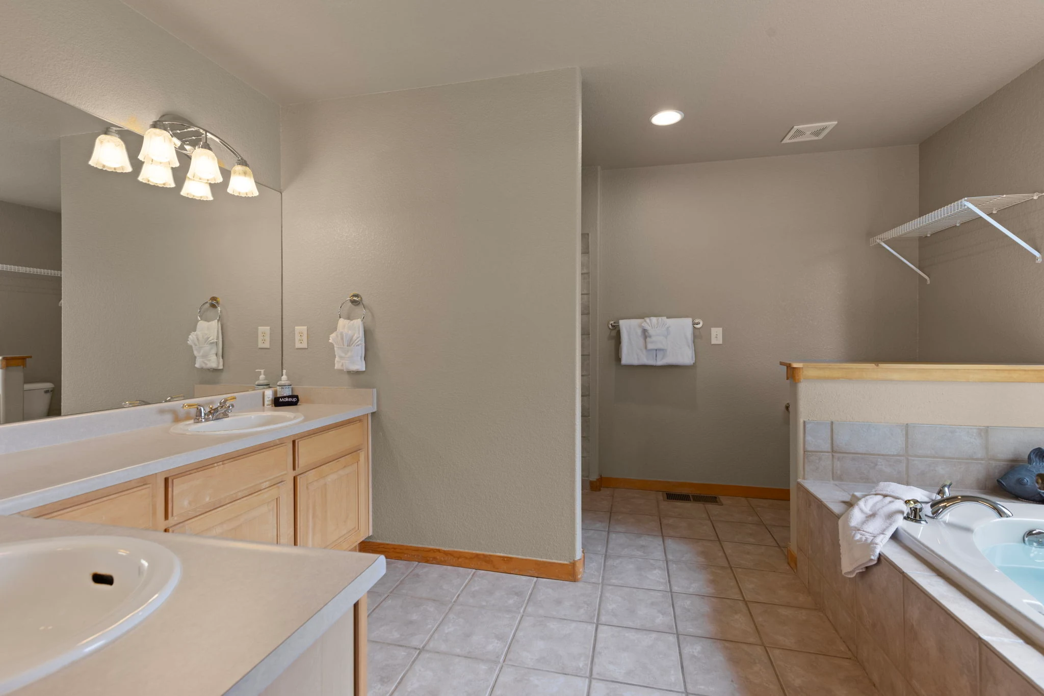 North Pond Retreat, Spacious bathroom with a double vanity, tiled floor, bathtub, and glass shower enclosure, waterfront vacation rental in Silverthorne, Colorado