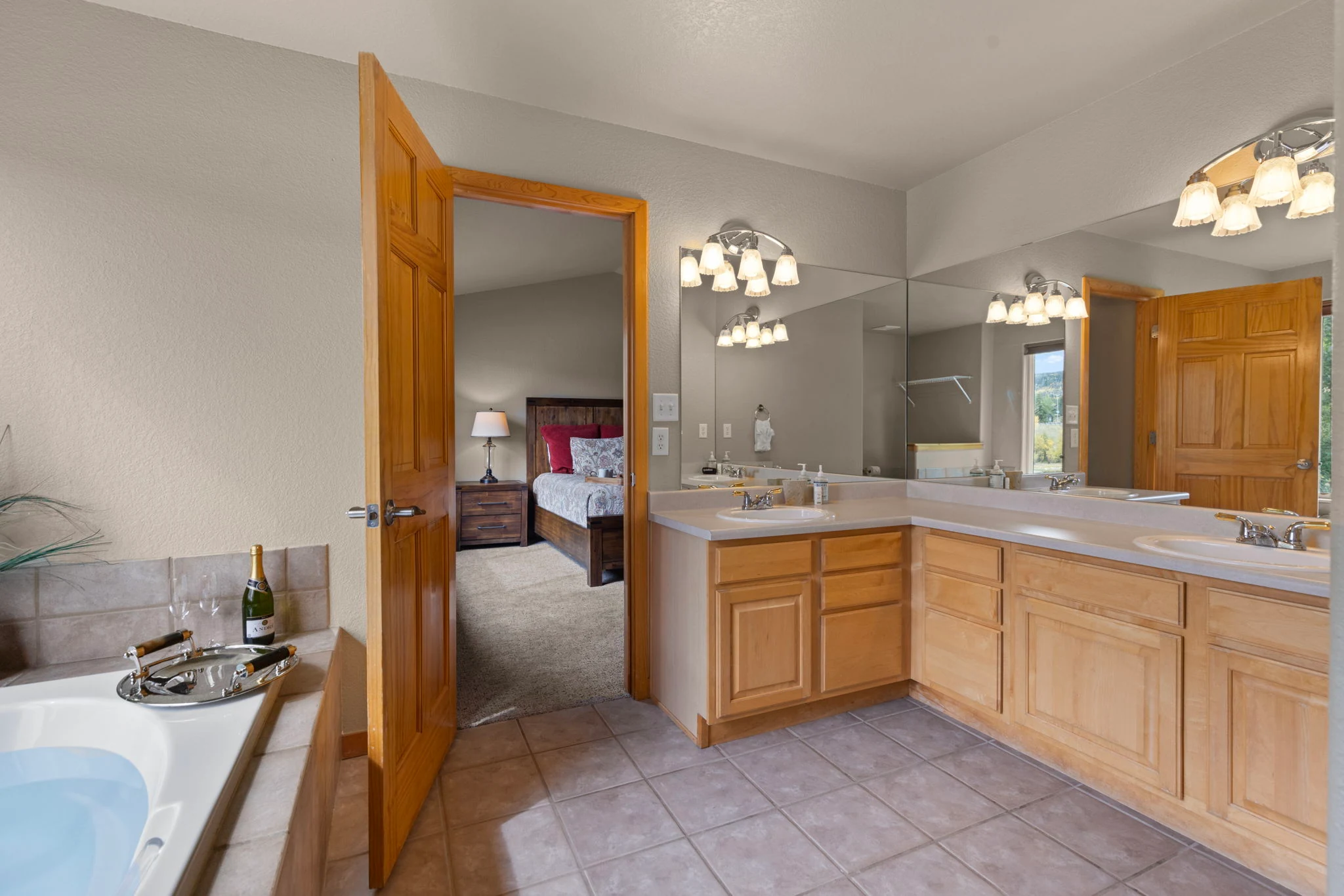 North Pond Retreat, Bathroom double vanity and mirrors beside the bathtub, with the king bedroom through the doorway, waterfront vacation rental in Silverthorne, Colorado