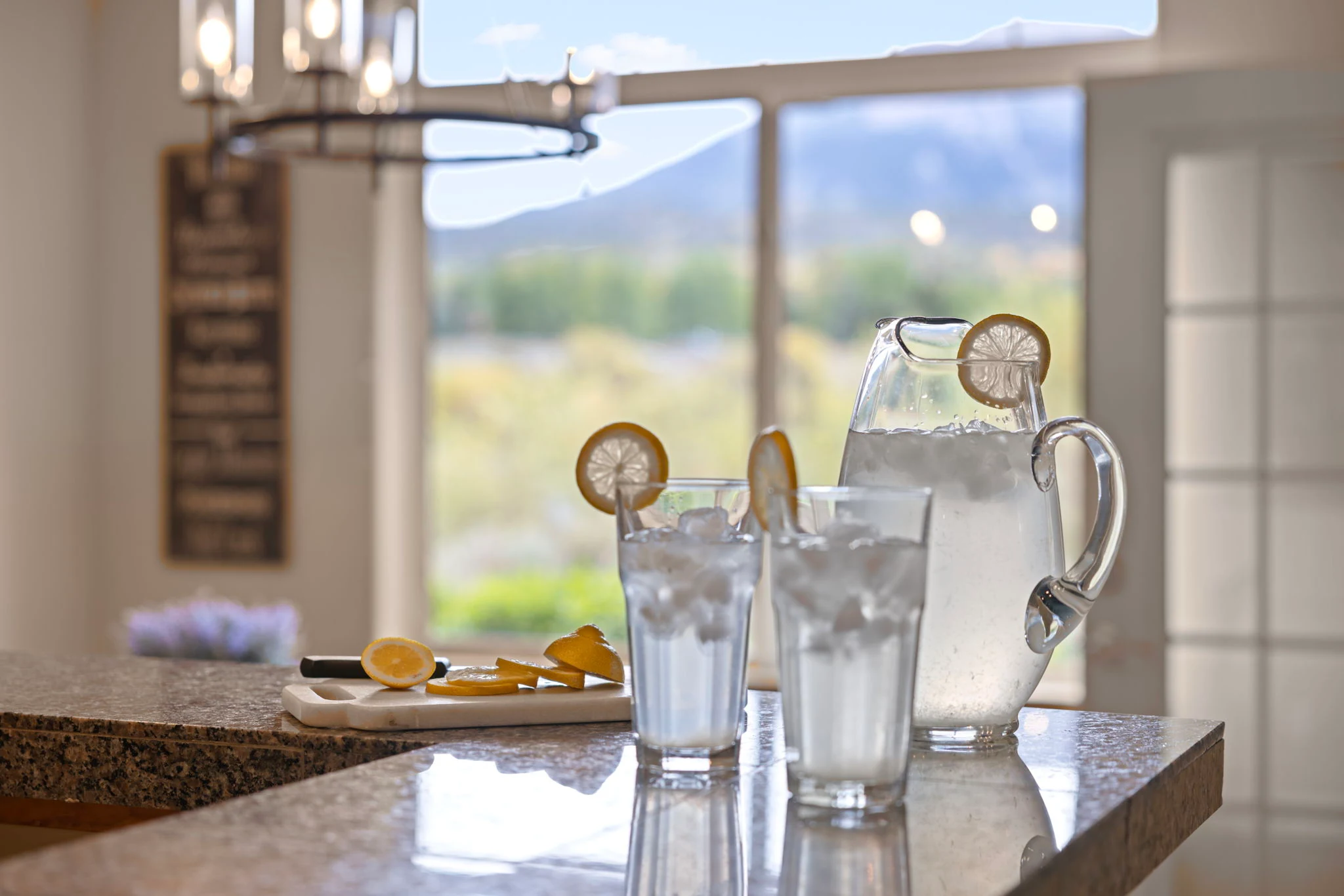 North Pond Retreat, Glass pitcher and tumblers on the kitchen counter, with mountain scenery beyond the window, waterfront vacation rental in Silverthorne, Colorado